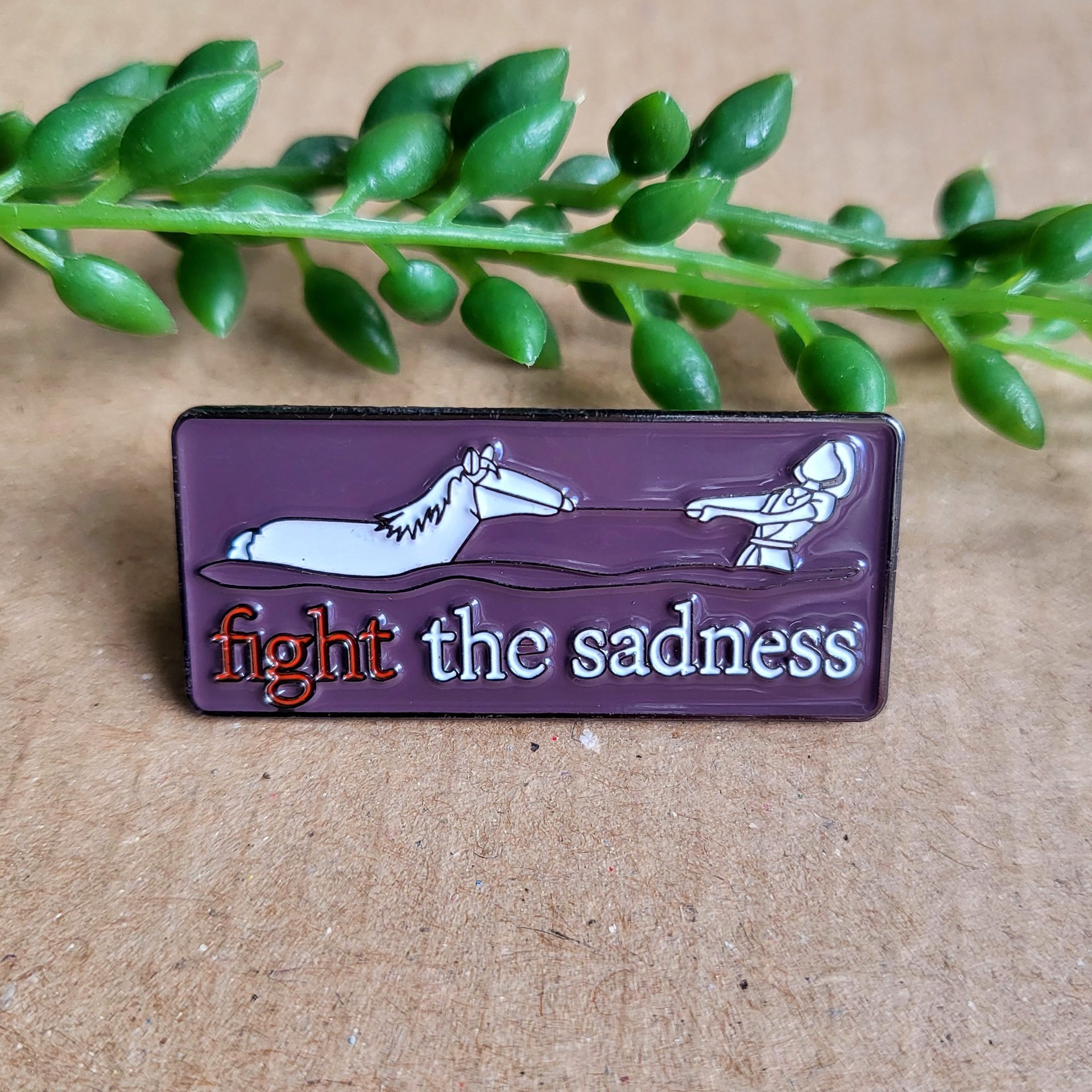 Fight the sadness enamel pin badge featuring Artax and Atreyu from the neverending story.